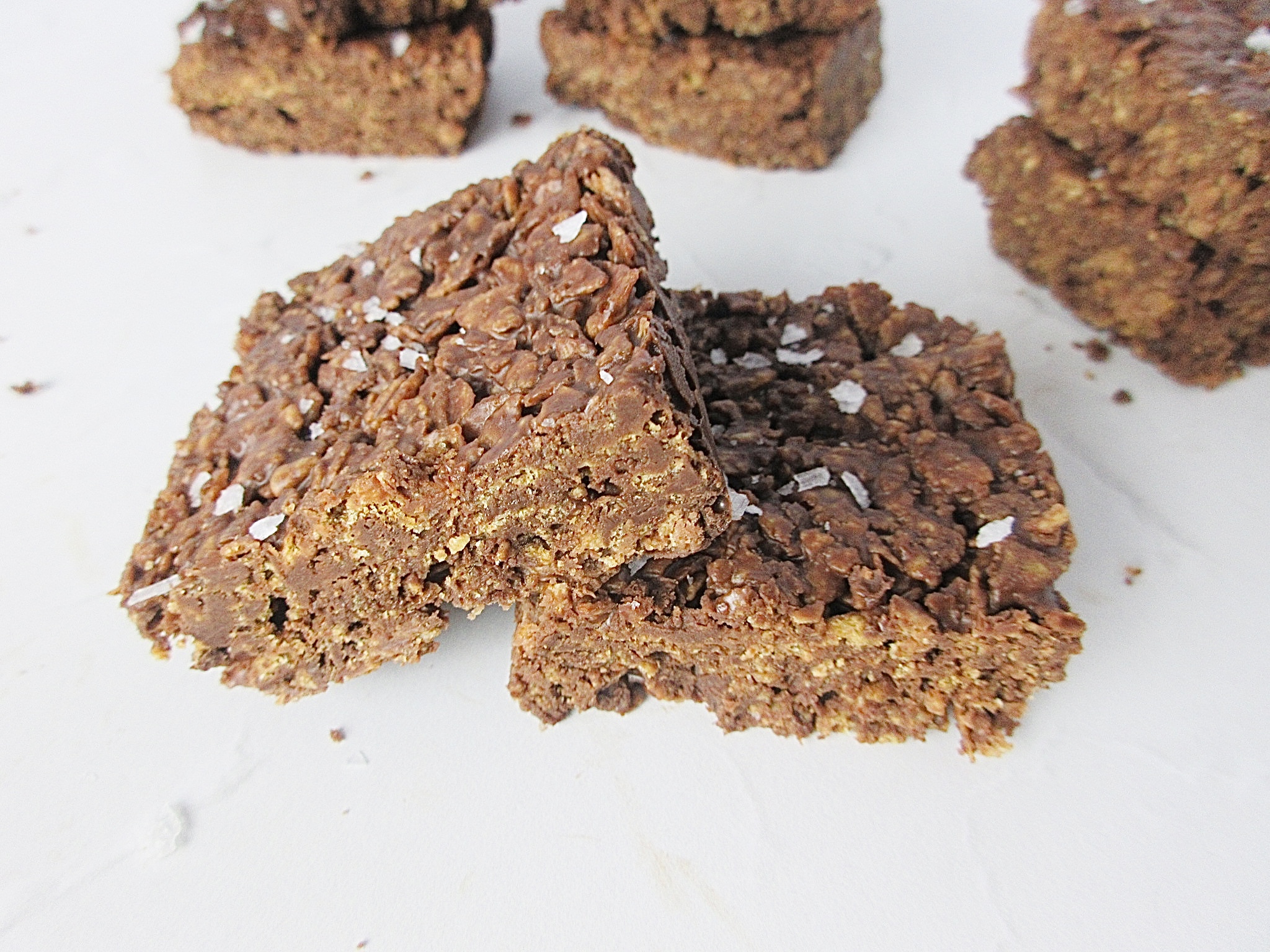 2 chocolate cornflake squares with some in the backgroud