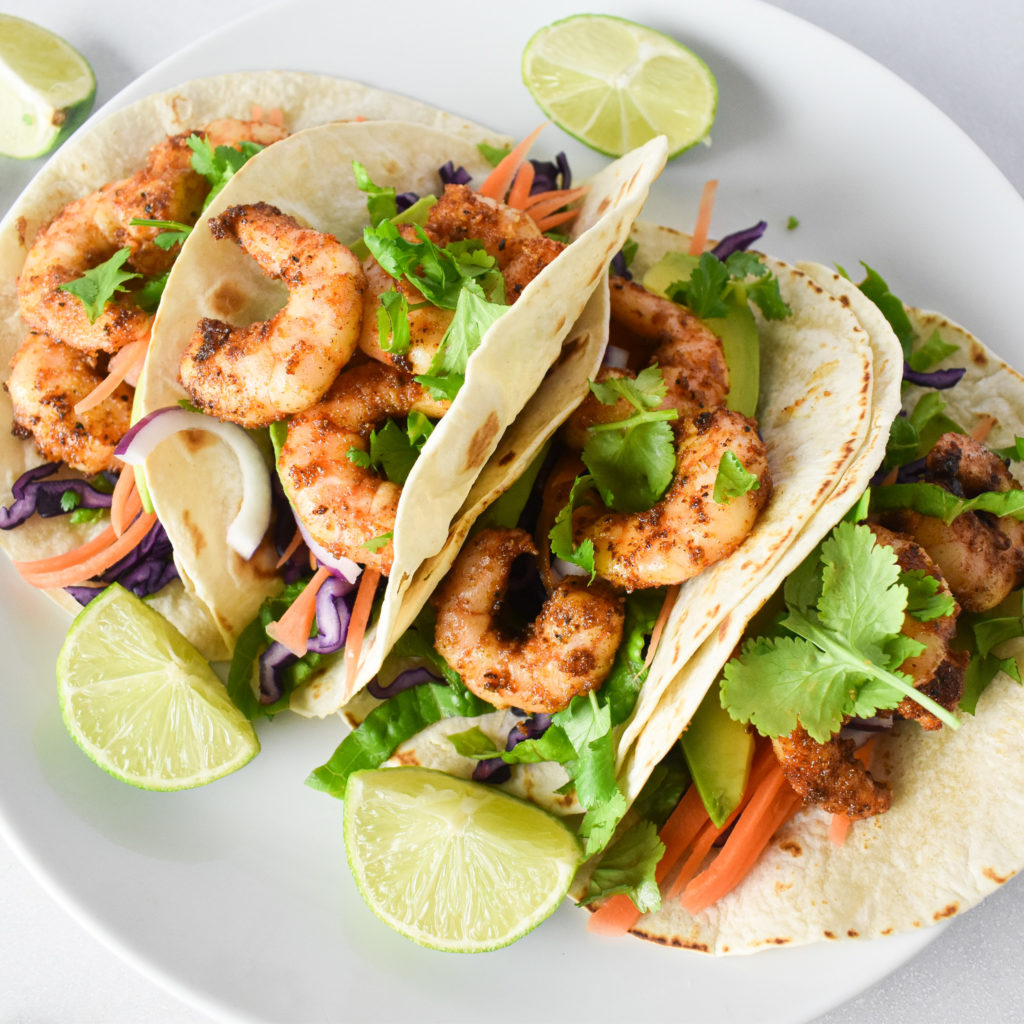 4 prawn tacos on a plate.