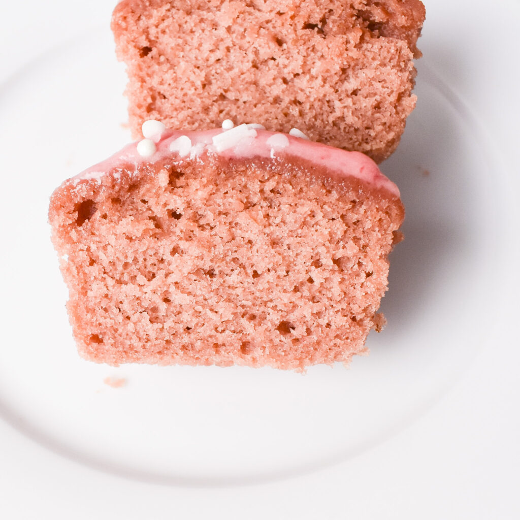 Pink strawberry cupcake cut in half.