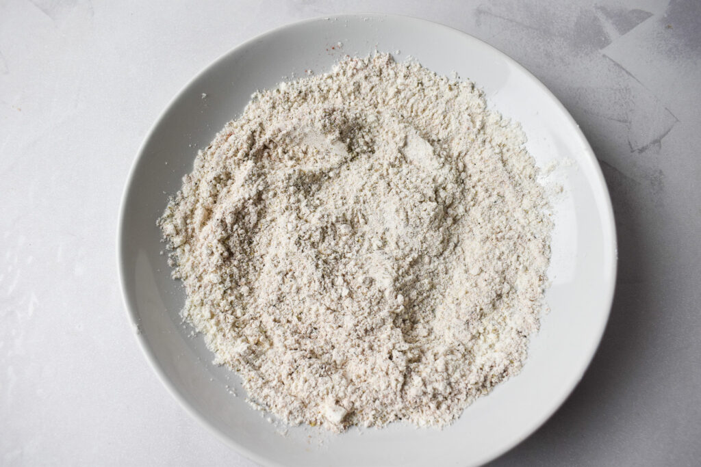 Seasoned flour in white bowl.