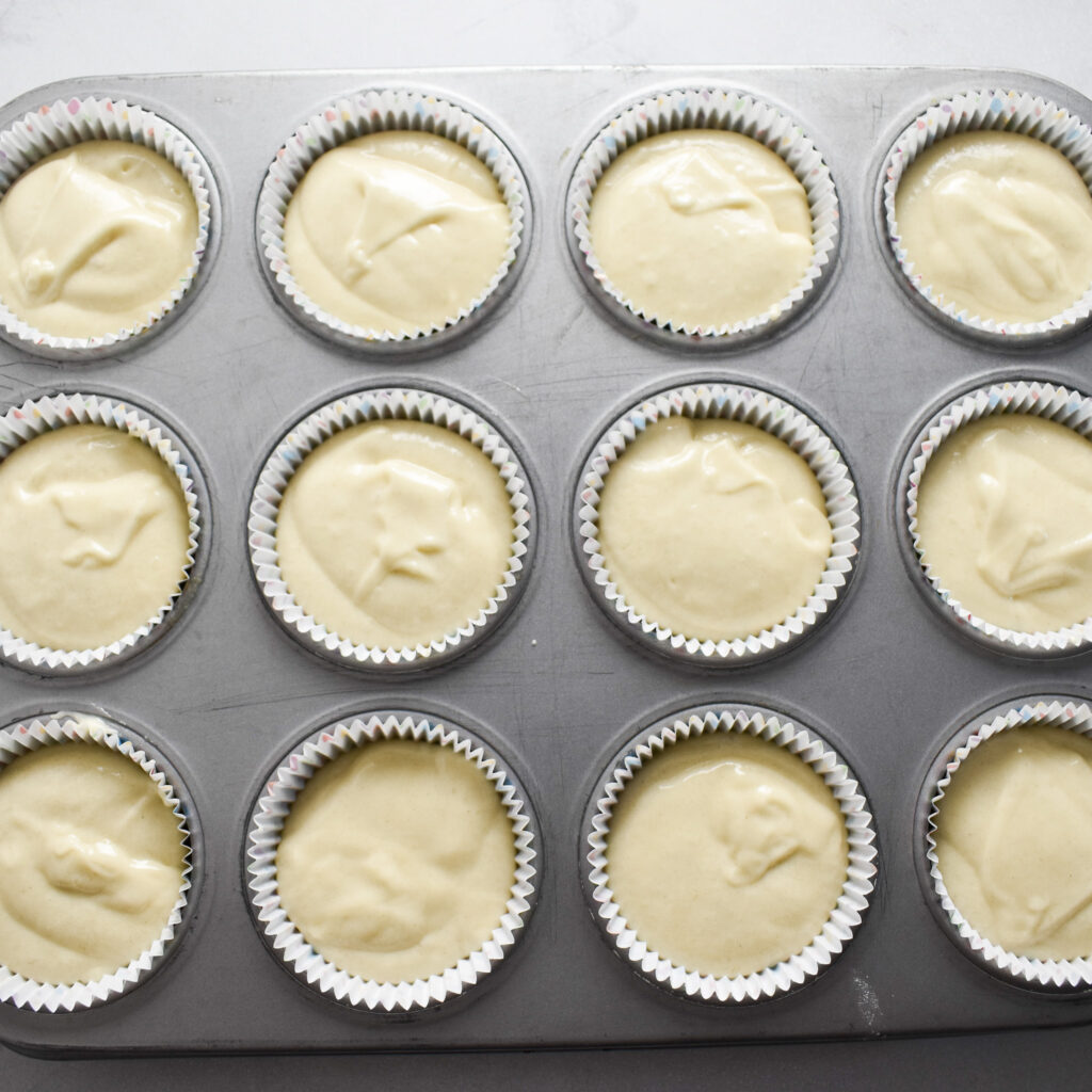 Unbaked vanilla cupcake batter in tin.