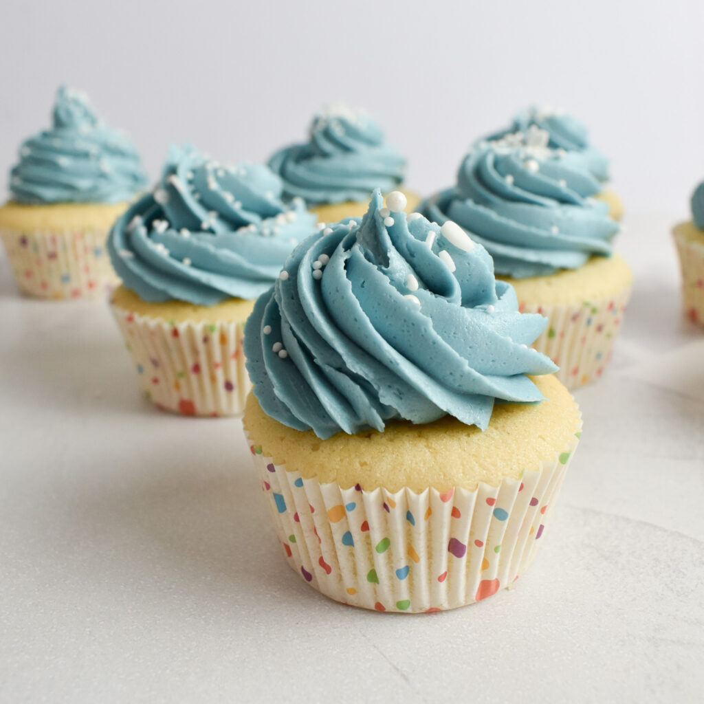 Vanilla cupcakes with blue buttercream frosting.