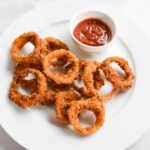 Crispy onion rings on plate