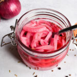 Pickled red onion in a pickle jar