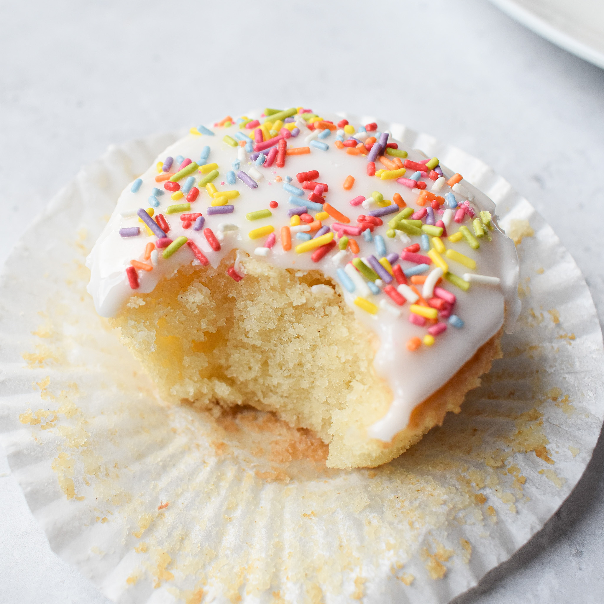 Glazed Vanilla Cupcake with bite taken